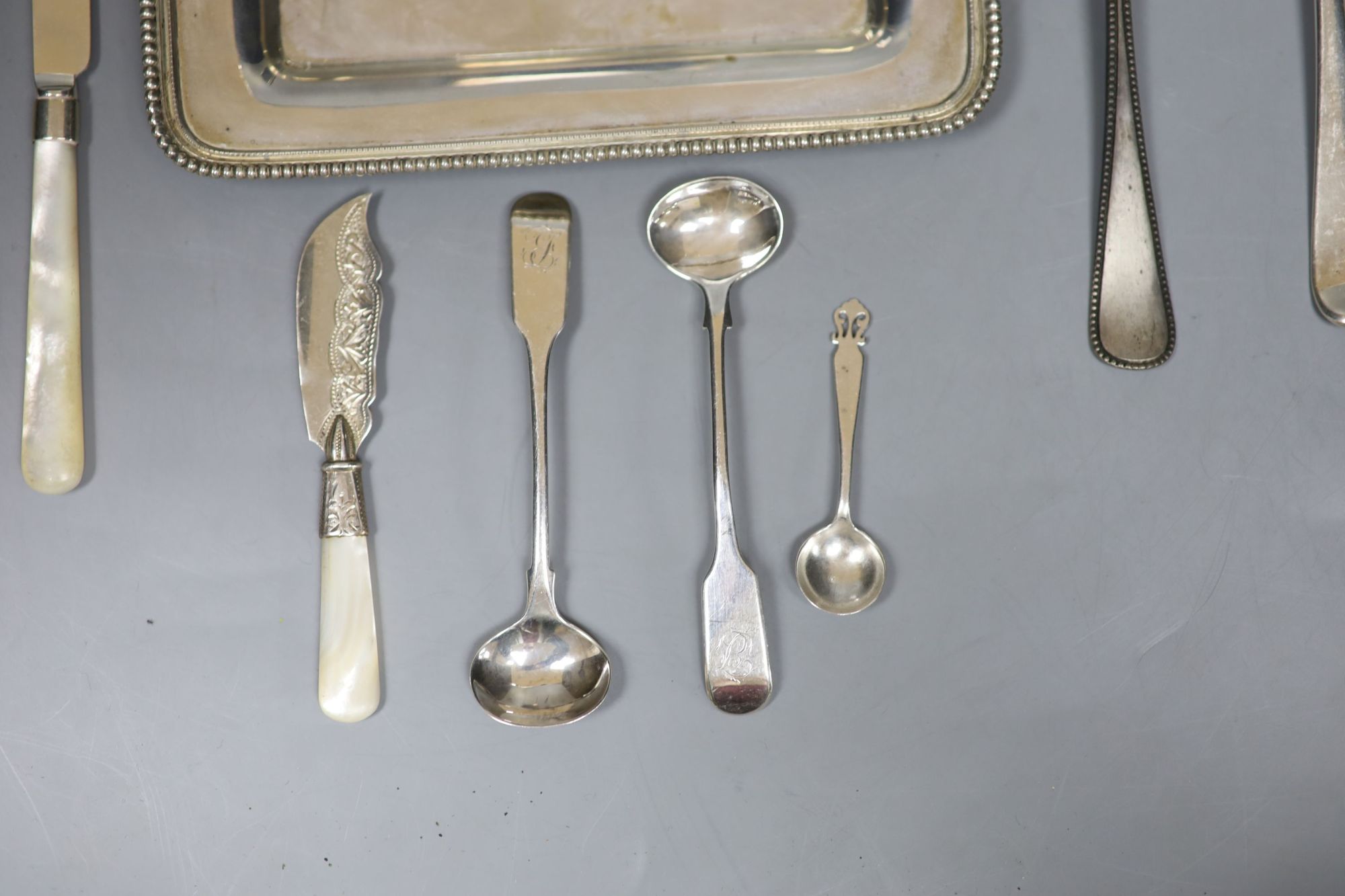 An 800 white metal stand, 16.4cm, twelve items of assorted silver flatware, a silver napkin ring, frame and box.